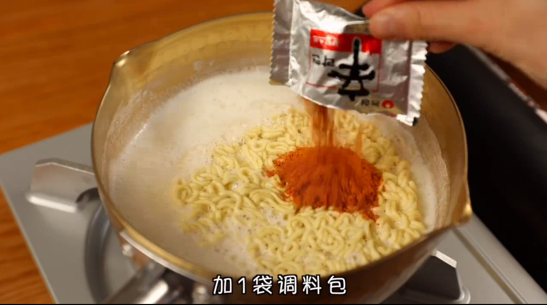 在锅中倒入200ml的水和200ml的牛奶,煮开后放入泡面和调料包。