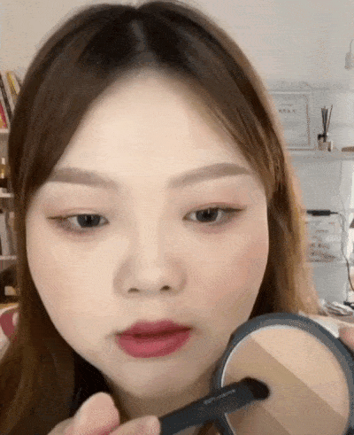 Step 2:之后拿出一个斜面的修容刷,沾取修容盘上的中间色;在鼻头上扫出V型,可以打造缩小鼻头的效果~往上扫一扫进行晕染。