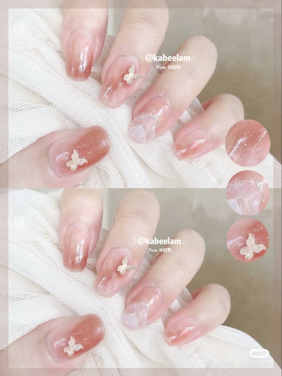 ✨玉脂果冻粉裸色系美甲 带杏橘调的冰透粉裸色系底色,小蝴蝶亮片点缀以及无名指的山丘纹渐变设计超级加分~