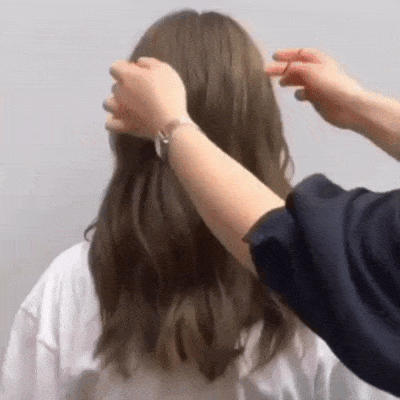 低马尾绑法(一): 1、抓起后脑勺一束头发绑起; 2、右侧和左侧各抓一束头发;偏左扎起。