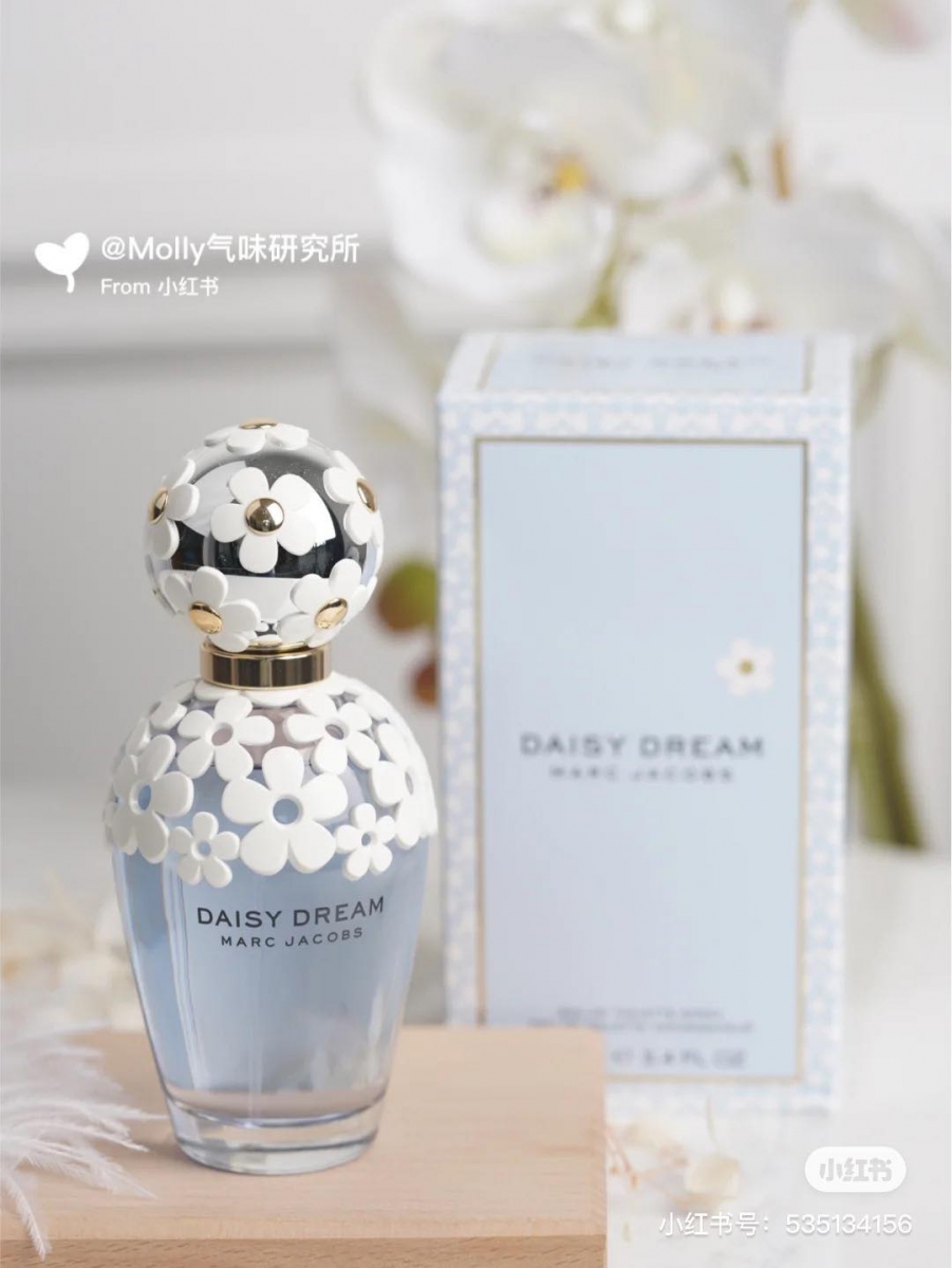 # MARC JACOBS Daisy Dream Eau de Toilette 香水瓶身被蕾丝状的小雏菊环绕,犹如湛蓝天空下被细风吹动的清新小雏菊。前调是黑莓、葡萄柚和梨,中调则是紫藤、茉莉和荔枝组成,后调有木质香、麝香和椰香,是款很有少女感、层次感花香中混着奶香调的春夏必备香氛。