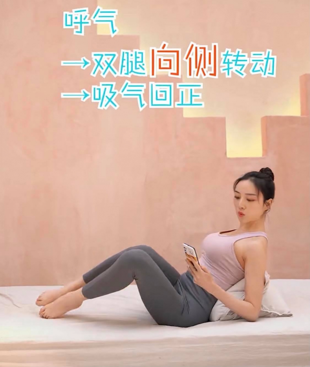 【边滑手机边瘦腰】动作一:半船扭转式(一组20次,共做3组)  坐在瑜伽垫或床上,后背靠在对折起来的枕头,屈肘支撑+双腿悬空。呼气时双腿向侧边转动、吸气回到原点、再呼气时双腿向另一侧转动;此为完整一组动作。重复20次 x 3组,有效帮助消除侧腰上的赘肉。