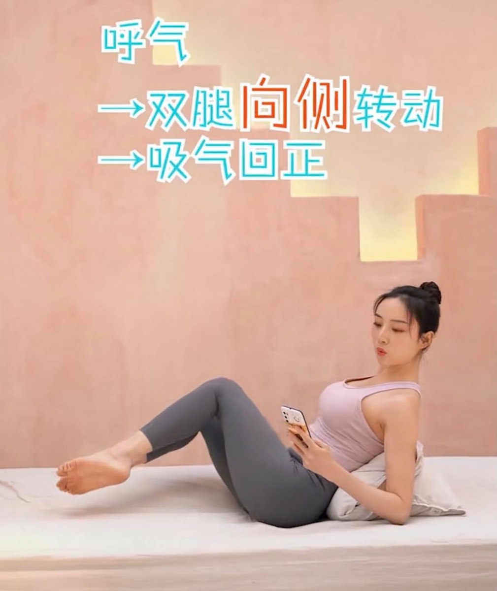 【边滑手机边瘦腰】动作一:半船扭转式(一组20次,共做3组)  坐在瑜伽垫或床上,后背靠在对折起来的枕头,屈肘支撑+双腿悬空。呼气时双腿向侧边转动、吸气回到原点、再呼气时双腿向另一侧转动;此为完整一组动作。重复20次 x 3组,有效帮助消除侧腰上的赘肉。