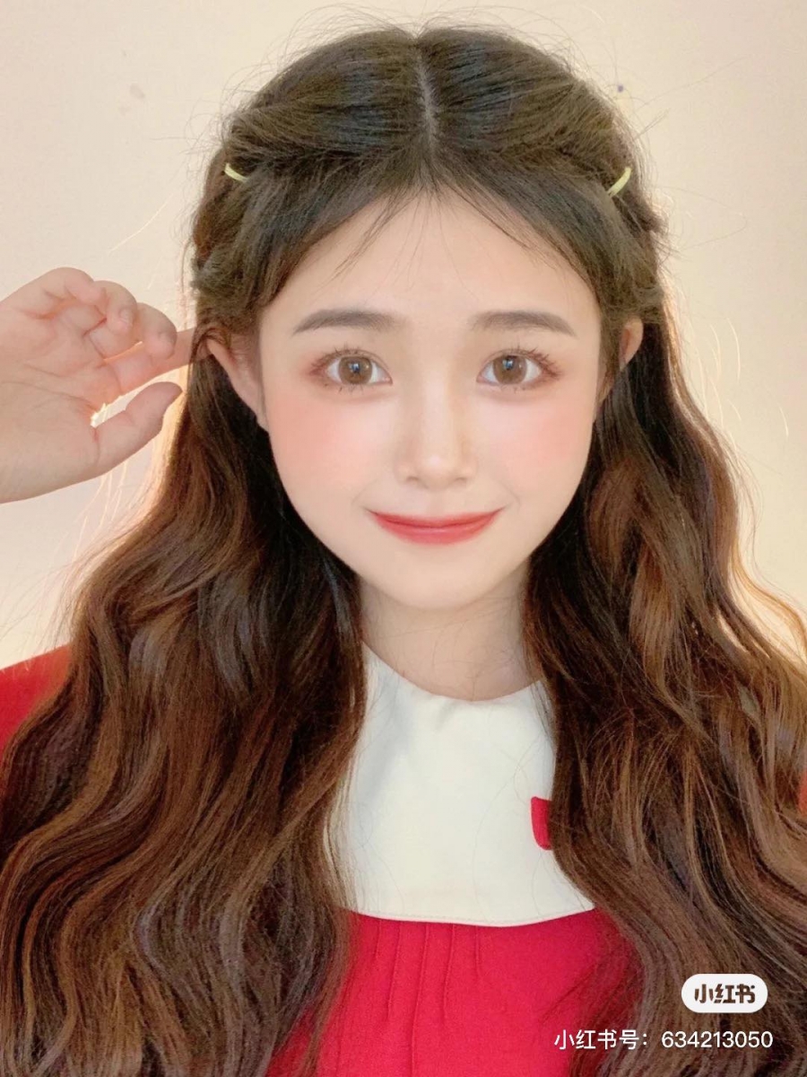 元气少女披肩发 3 : 头顶取一撮头发用发圈扎起来,将其往内翻转;往下加入耳边的一点发丝汇合扎起来,再继续往内翻转动作。将鬓角和发际线碎发拨出来修饰脸型即完成!这款不加发夹也已经很好看了呢~