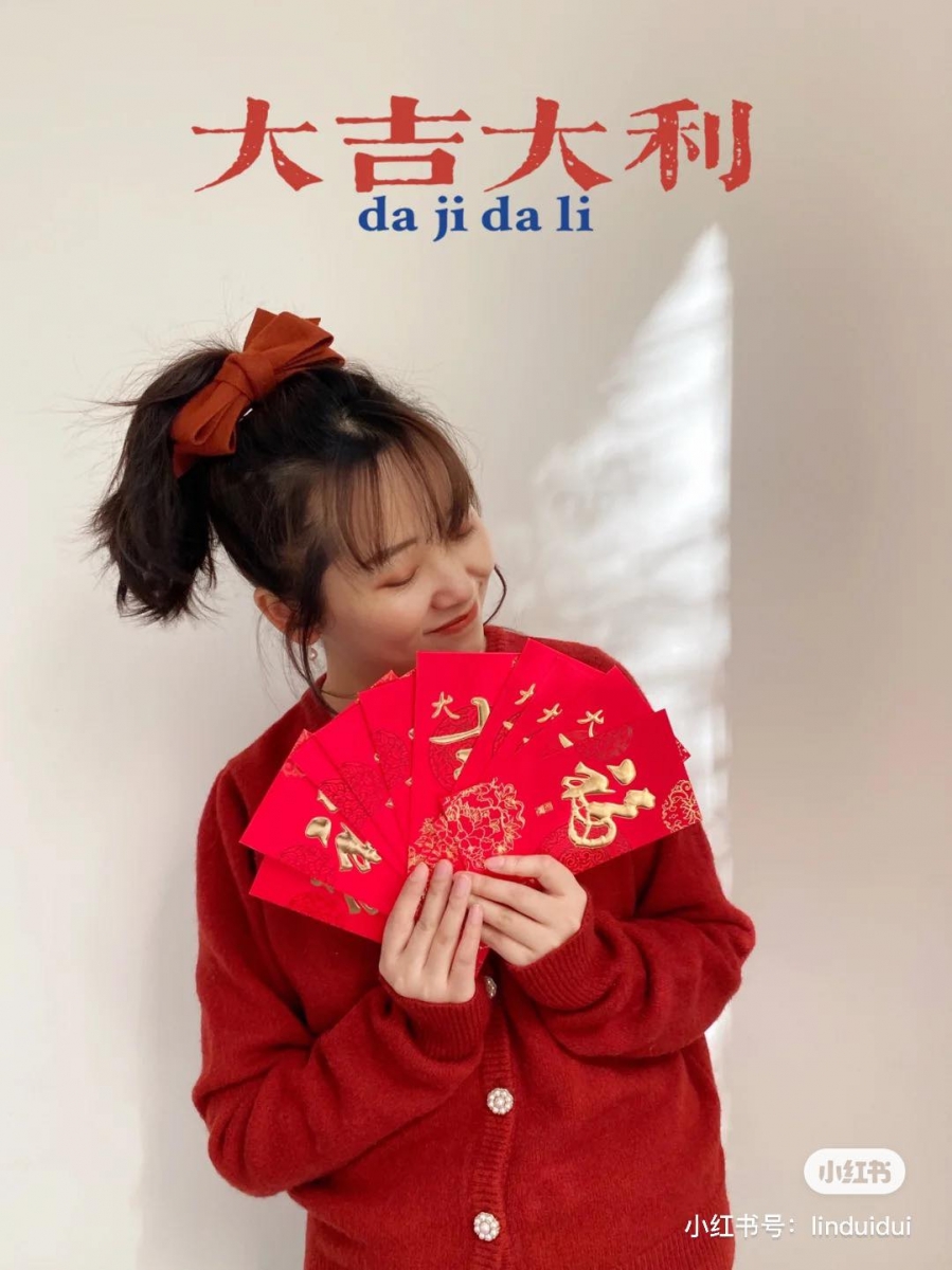 觉得上面的方法还是太复杂?那就在同一面白墙前,手里拿着年味满满的小道具、摆好Pose拍几张写真~上方留白位置可以用黄油相机添加花字即可!