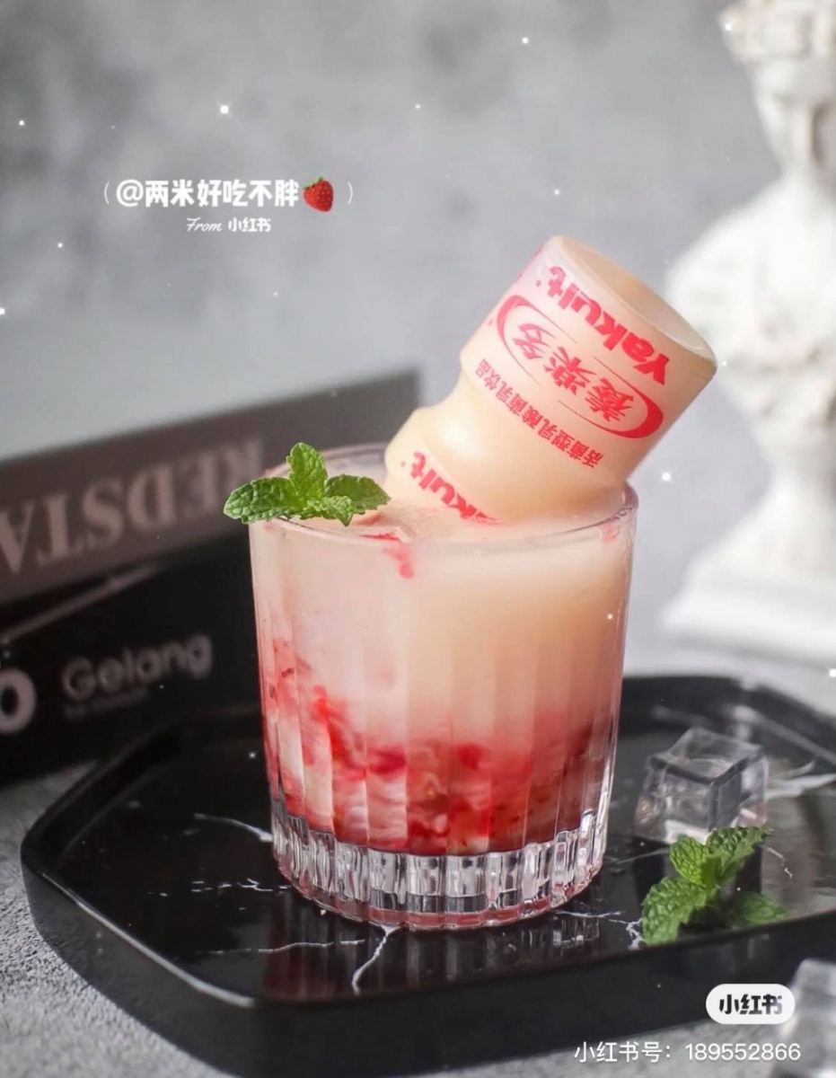 在杯中倒入切块的草莓果肉和蜂蜜后捣碎,然后加入冰块,再倒入适量气泡水,最后倒入养乐多即可。比起奶茶健康得多~颜值还很高呢!