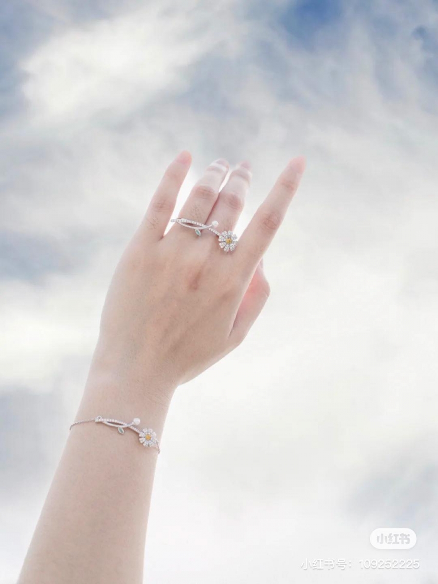 # BABYBEI 小雏菊戒指 轻奢设计师珠宝品牌BAYBEI旗下推出过的一款小雏菊戒指，是一整株连花带茎叶的小雏菊设计，花蕊和叶子部分还有彩宝点缀，十分有特色。