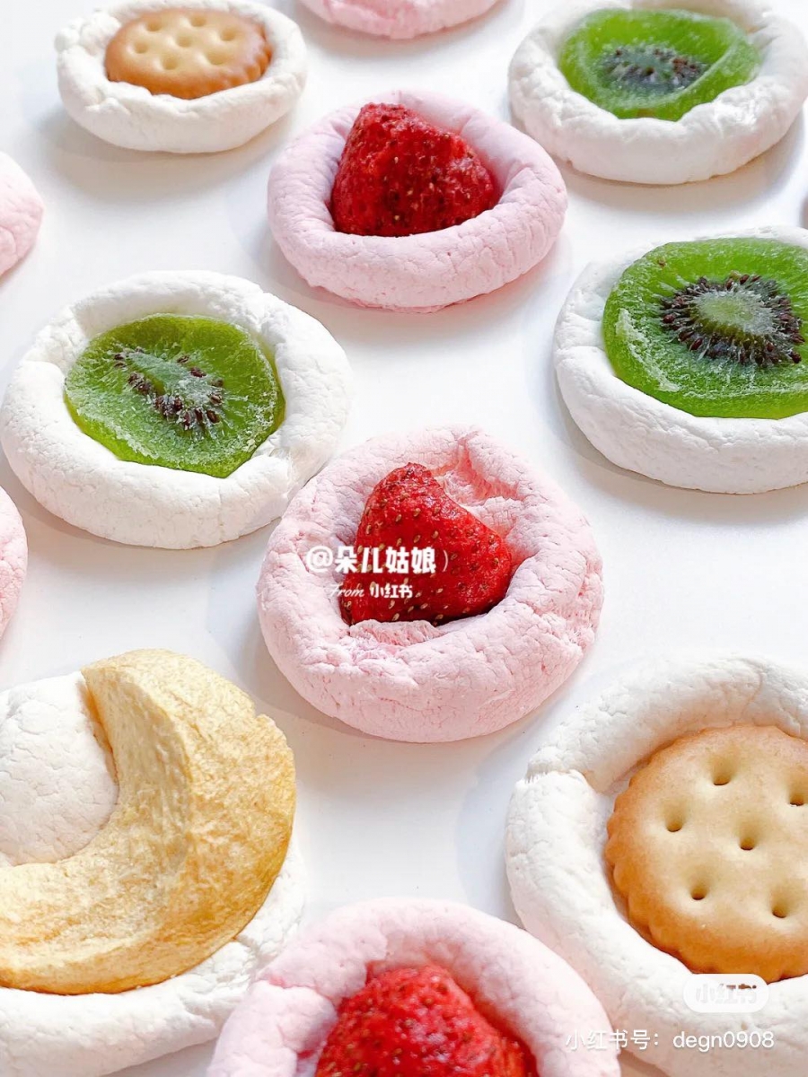 2、取出后趁热把冻干水果、小饼干按进棉花糖里，待冷却后棉花糖会变得酥酥脆脆口感超好！