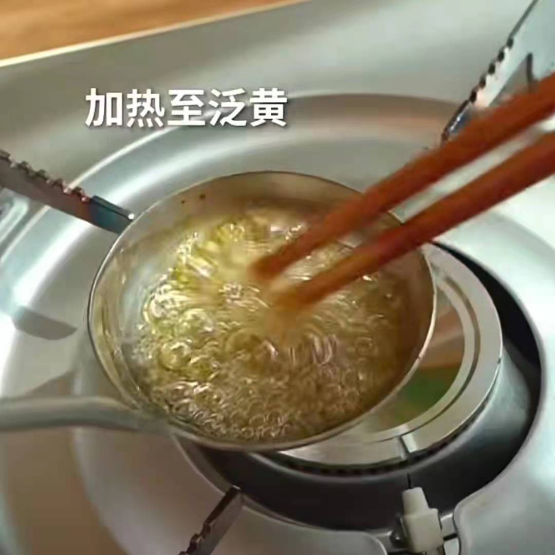 开中火熬糖,加热直微微发黄(如图)稍微搅拌避免烧焦!等糖全部融化后,加入一小勺小苏打,快速搅拌直膨胀!