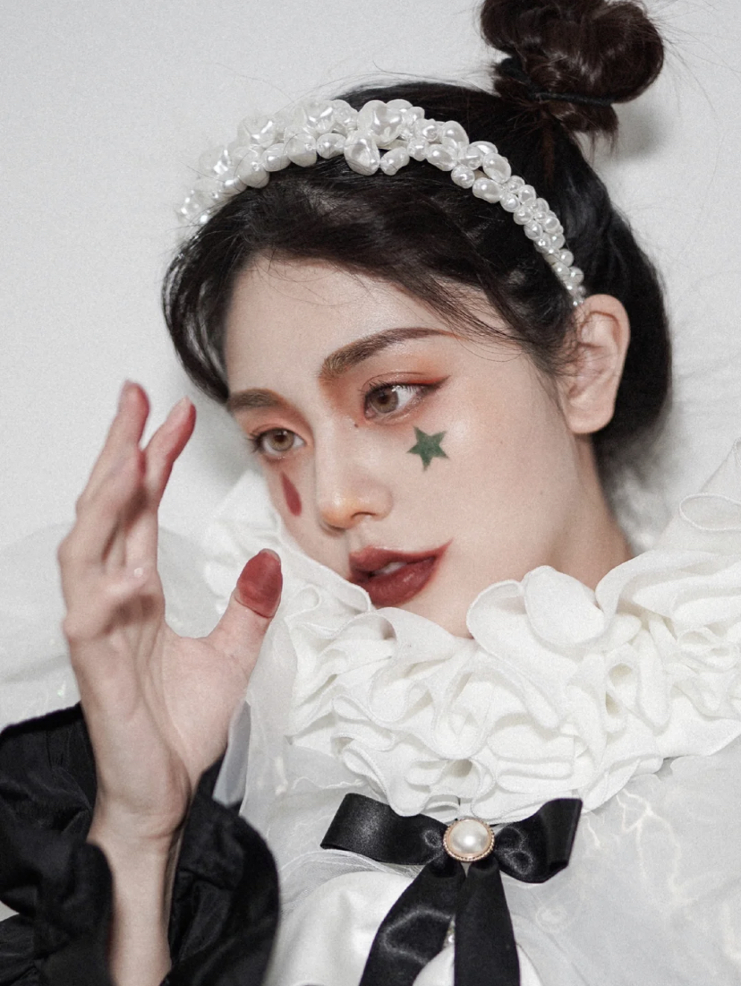 先用红色眼影大范围晕染整个眼部。接着画上细长的上扬眼线,用红色的眼影在眼下画出泪滴形状,再用绿色眼影画上五角星就完成啦~