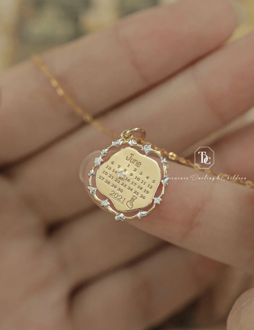 简约的18K金牌上有着日历元素的设计，外圈次用了星星和爱心的造型