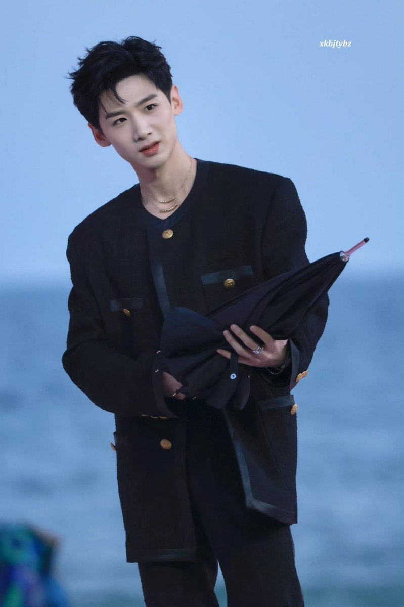 白敬亭一袭落地喇叭裤搭黑色长外套演绎帅气不羁魅力，走T台式还配了把黑伞。