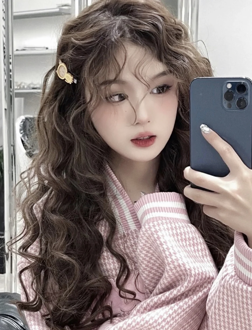 蛋卷长发可以很好的修饰脸型,带有温柔又慵懒的气质。脸颊的两侧卷发可以让脸部线条更柔和,间接看起来会是精巧的小圆脸啦~