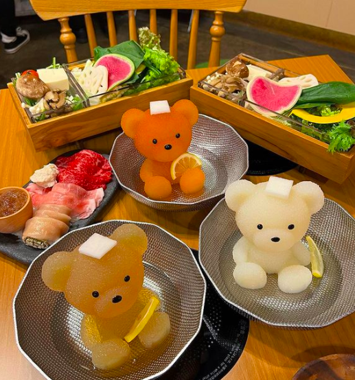 看清楚一点原来是店家将汤汁以食物纤维和胶原蛋白固定成小熊的形状，然后开火加热后小熊就会慢慢融化成火锅汤中