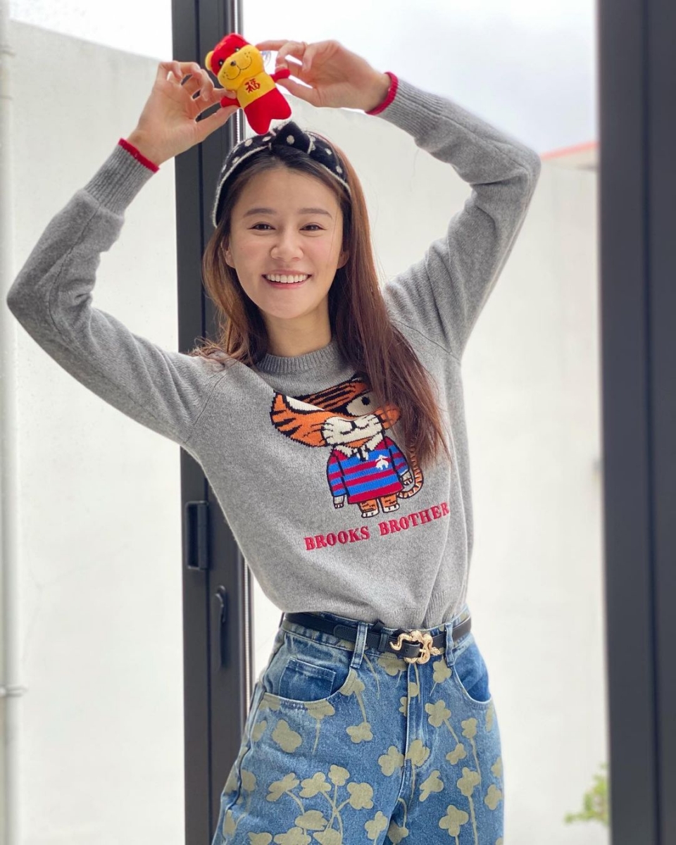 到了下一张则是黄翠如身穿印有老虎的灰色长袖上衣，手上拿着小老虎公仔对着镜头灿笑，满脸幸福的样子～