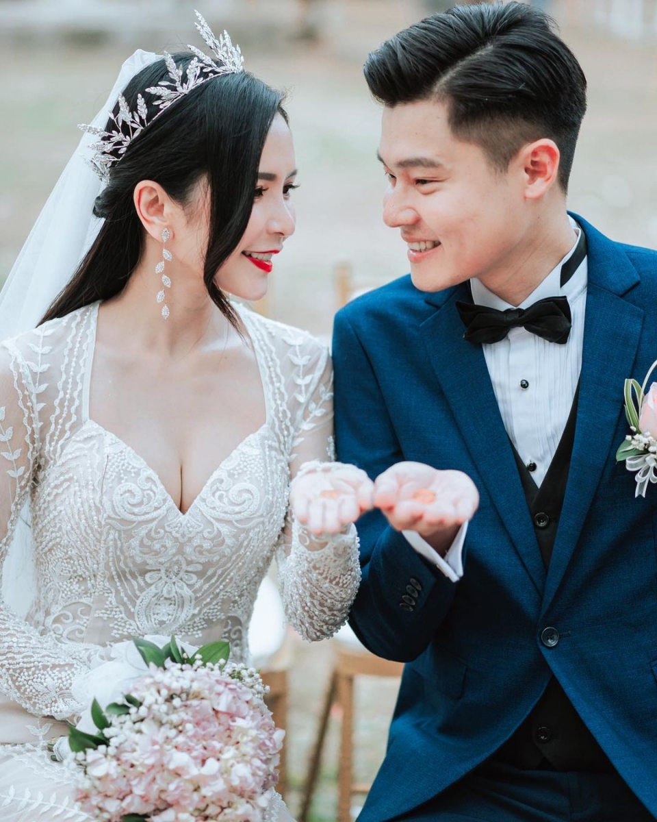 照片中的两人穿着婚纱和西装礼服，一脸甜笑含情脉脉地互望着对方，超Sweet的～