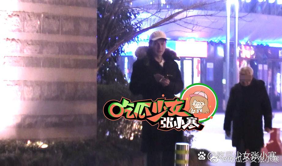 有一位戴着白色鸭舌帽的帅哥在小区门口等候她。