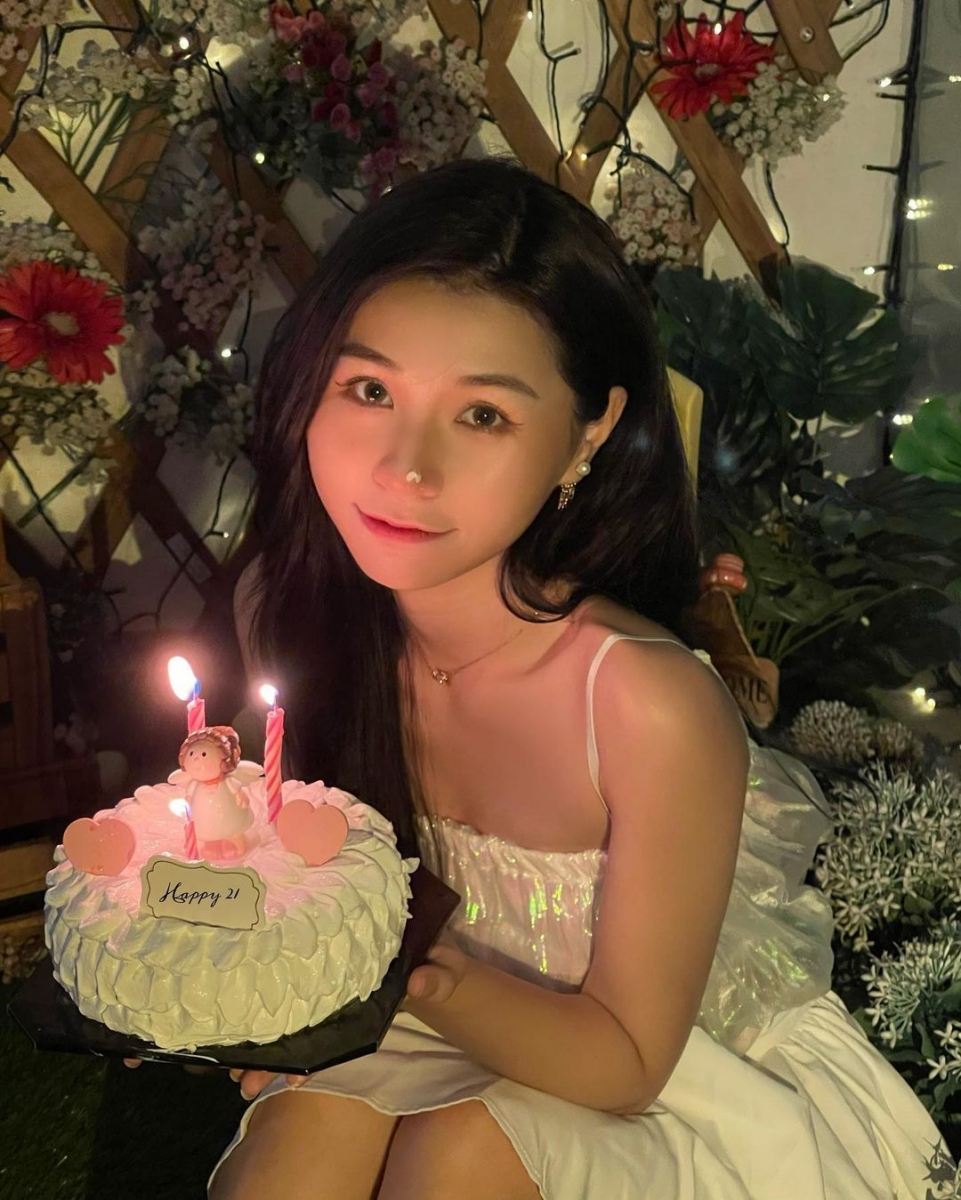 照片上,她穿着白色吊带连衣裙,手捧着蛋糕对着镜头甜笑,配文声称:「叮咚,又按时长大喽」~