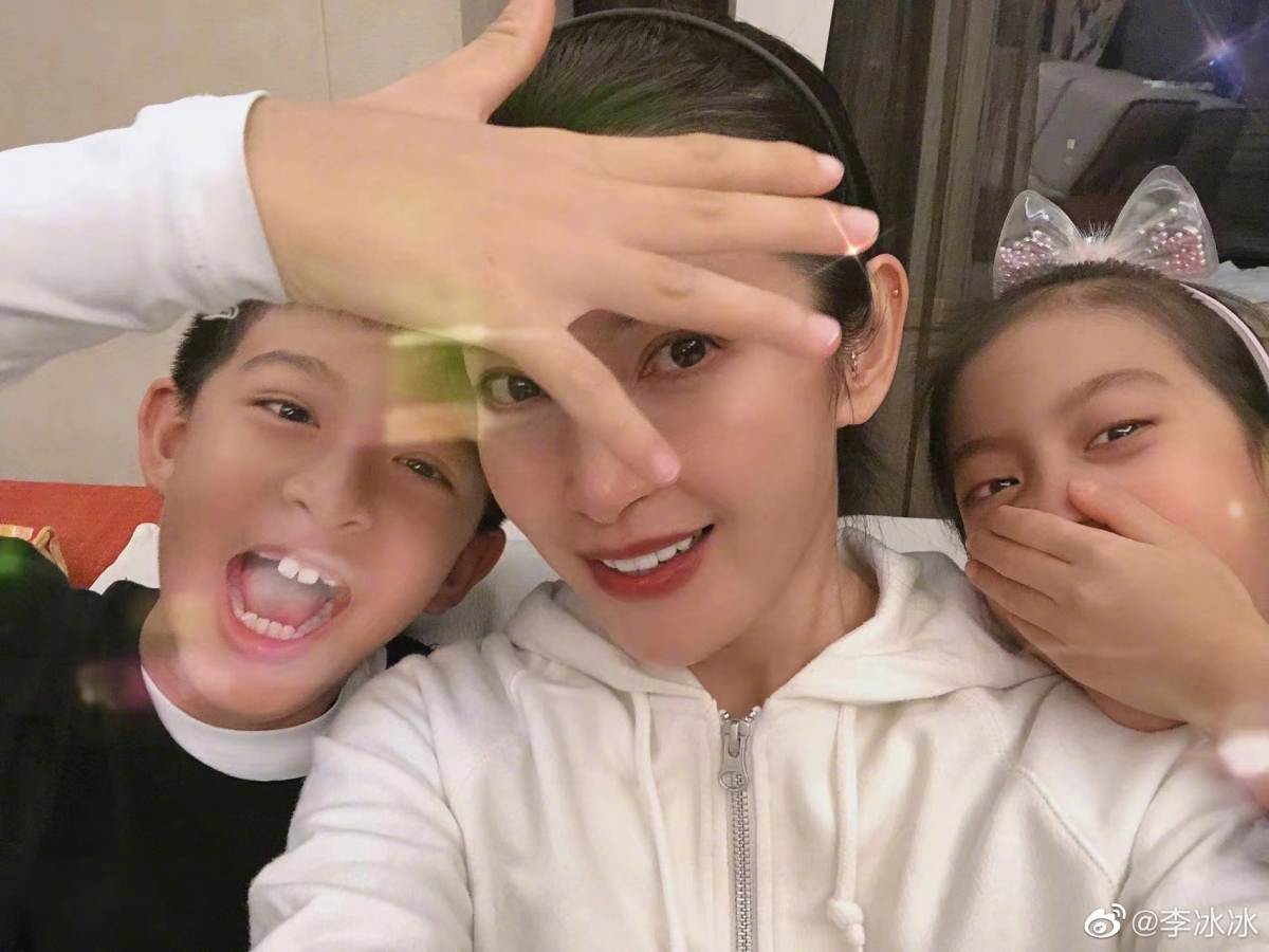 可以看到李冰冰素颜而朴素的打扮,两个外甥分别在她的肩膀两边,画面看起来很是温馨幸福~