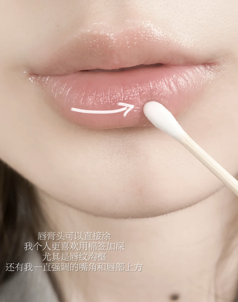 Step 2、用滋润型的护唇膏厚涂上唇，过程稍微用些力来回左右摩擦，静敷10分钟后用温水化妆棉擦拭掉护唇膏