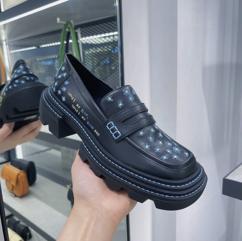 有着蓝色雏菊花的刺绣以及「Loves Me Blue, Love Me Blue Not.」的字样设计