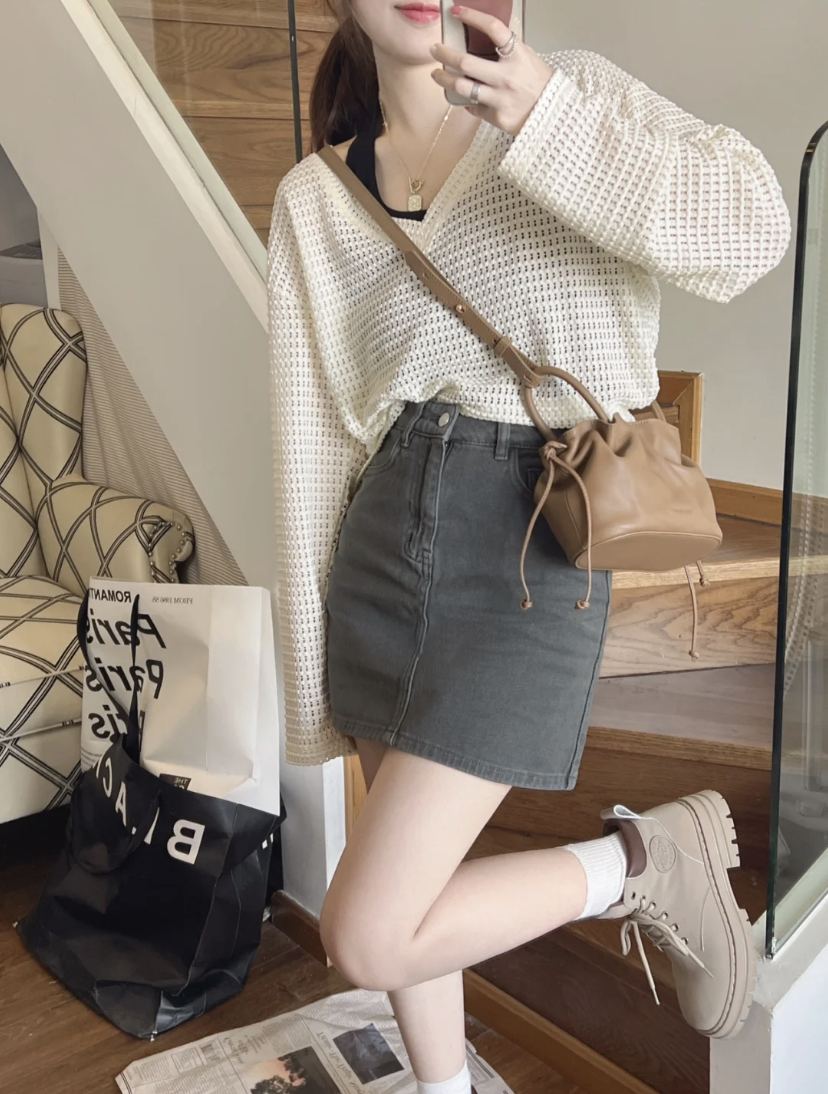 奶油色系上衣搭配高腰短裙,这样的搭配可以延长腿部的线条,再搭配马丁靴可以让双腿更修长