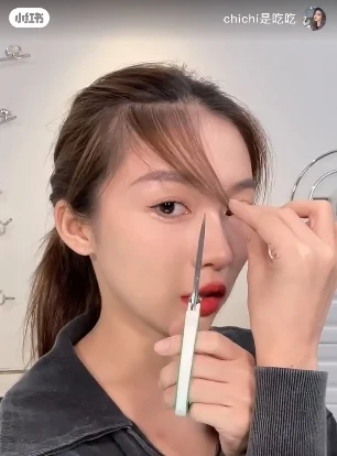 然后一手拿着一把剪刀,把剪刀垂直拿住