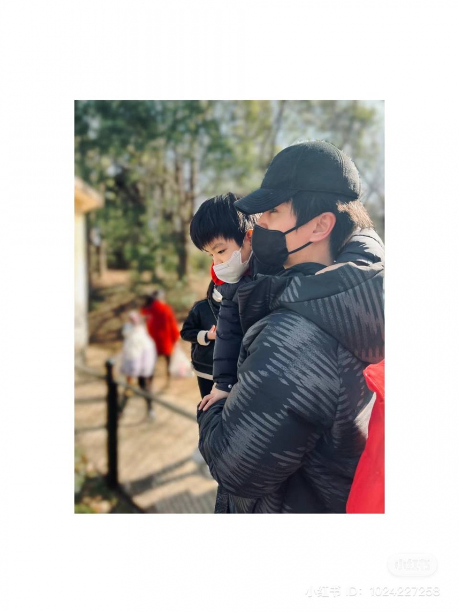 只见陈晓抱着小星星在目视前方，陈星星则一脸好奇地低头探察，而陈妍希在一旁定格了这个画面。