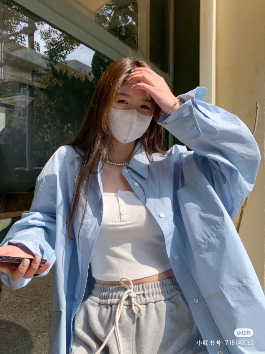  只需把衬衫的纽扣全部打开，内搭一件短款小背心