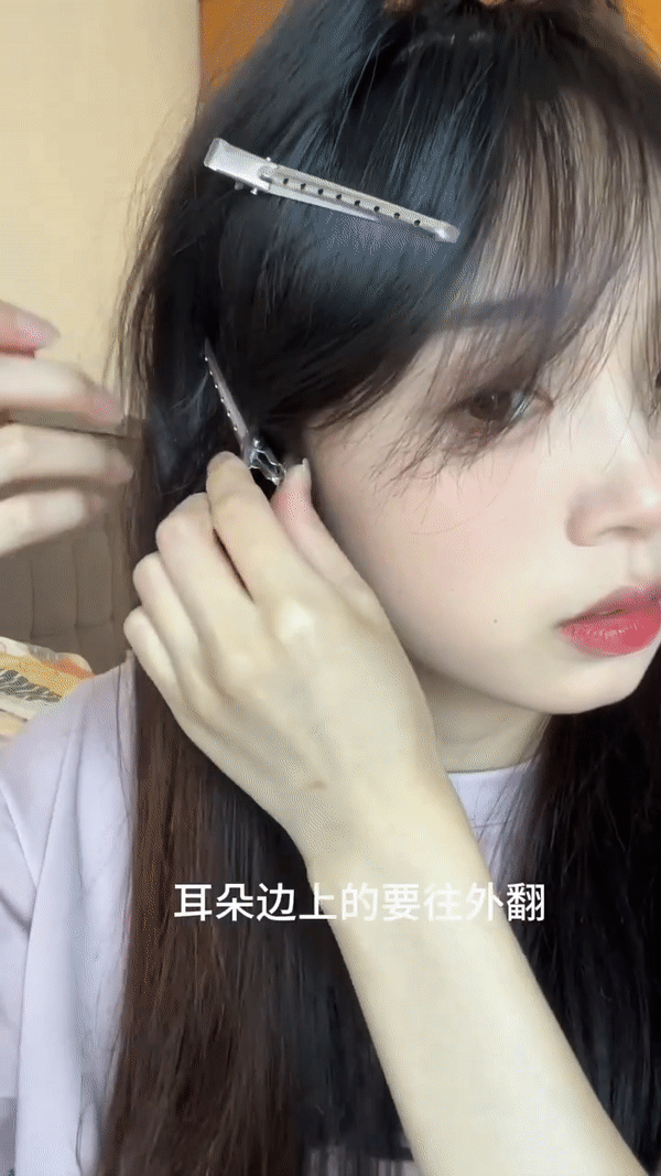 2、夹住耳边的头发往外翻